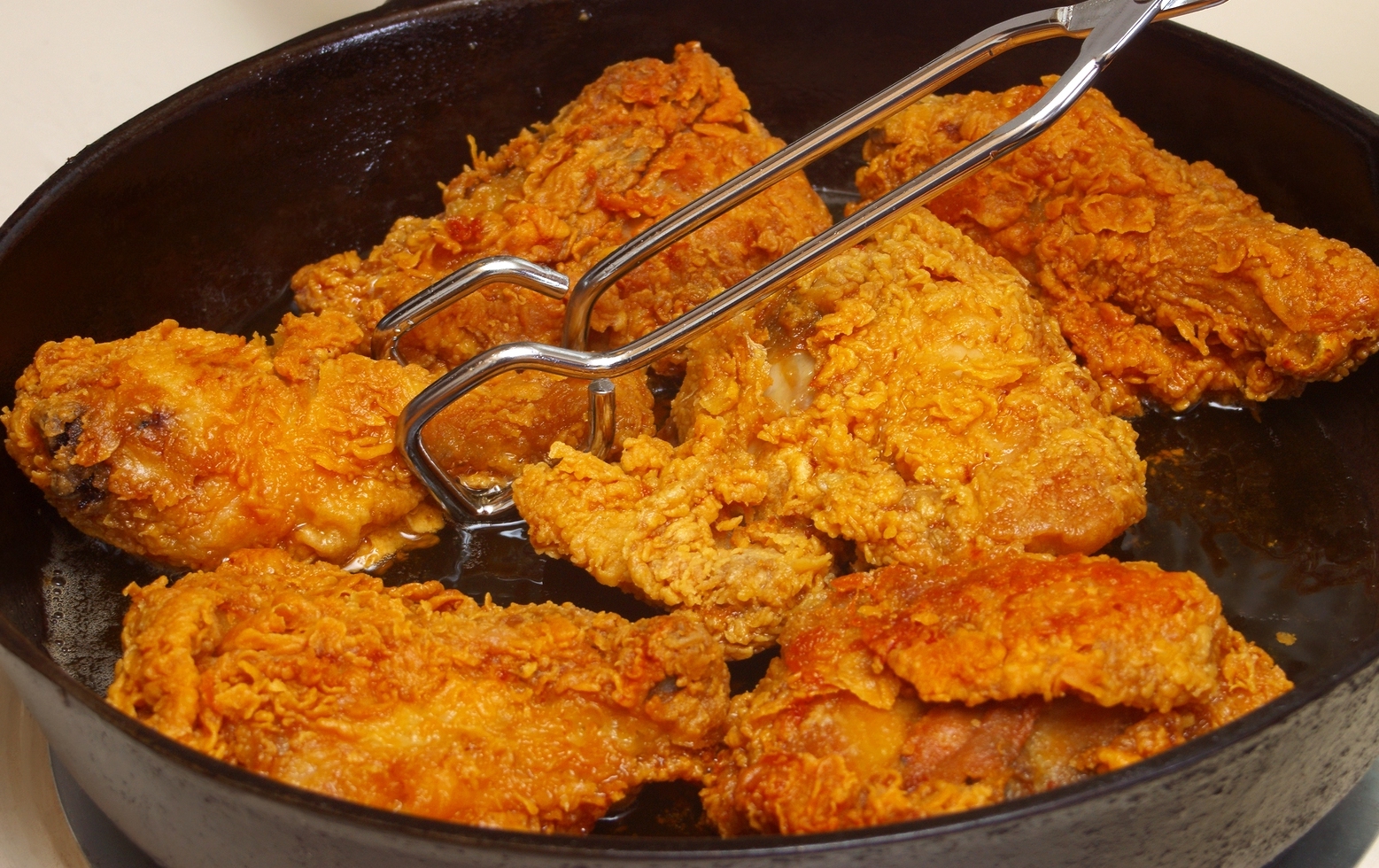 Chicken cooking in a cast-iron frying pan